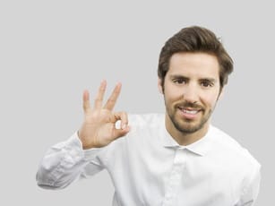 フランスから来た、OKサインを出す白いシャツを着た男性。 shutterstock_130481999