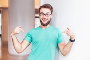 フランスで眼鏡をかけた男性が壁に指を向けている。 shutterstock_217818265