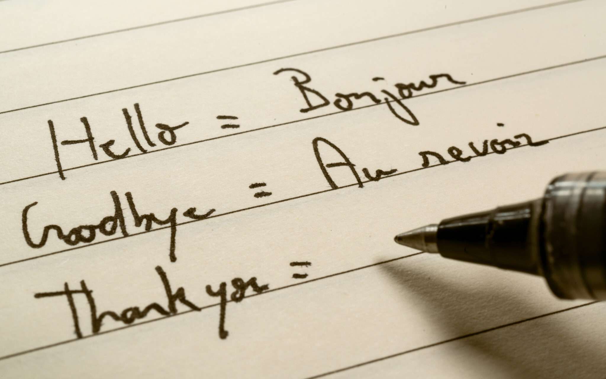 フランスから来たペンが紙に「こんにちは」と「さようなら」を書いています。