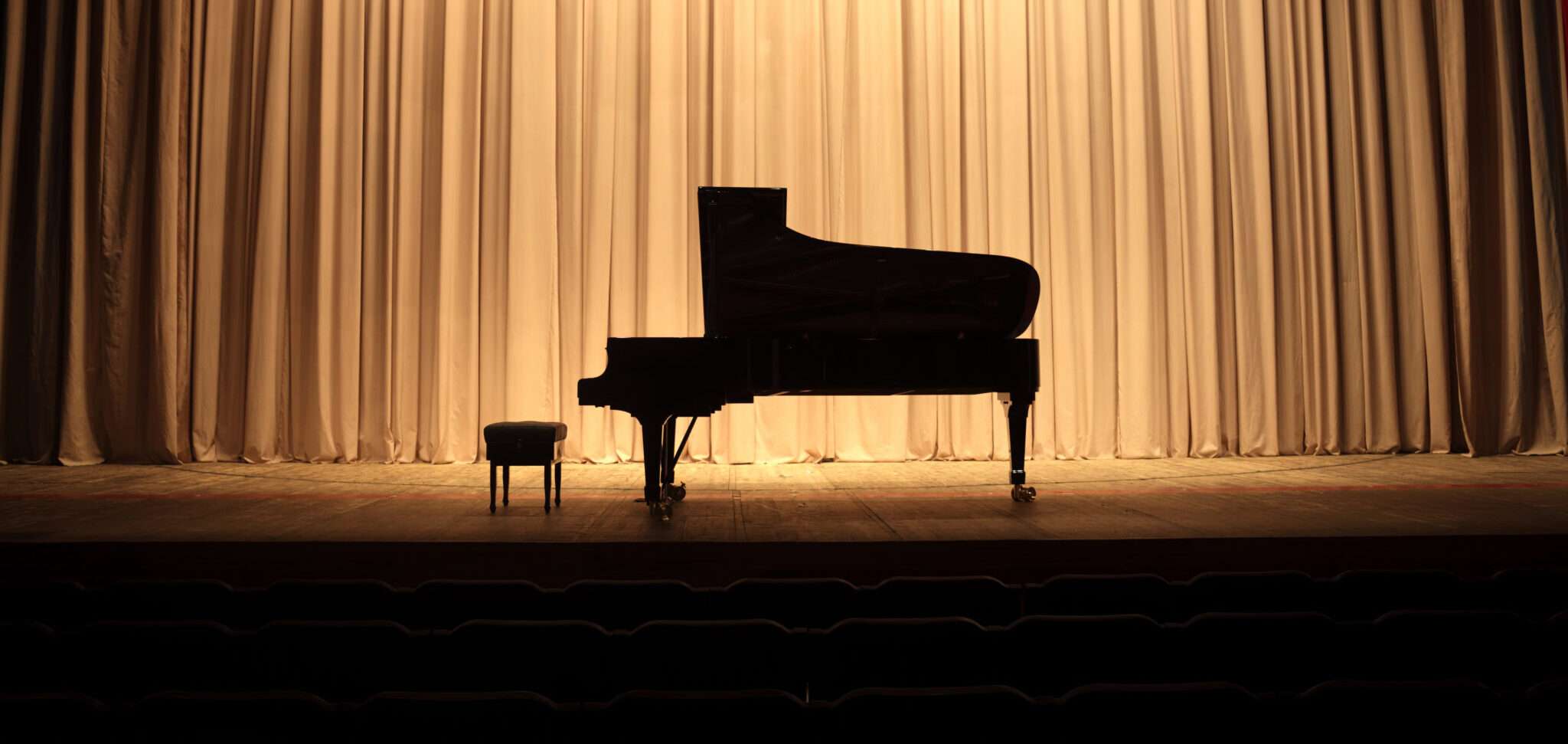 フランスのオーディトリウムのカーテンの前にあるグランドピアノ。