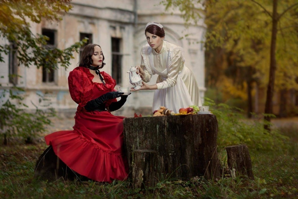 フランスの切り株に座る赤いドレスを着た2人の女性。 shutterstock_178955924