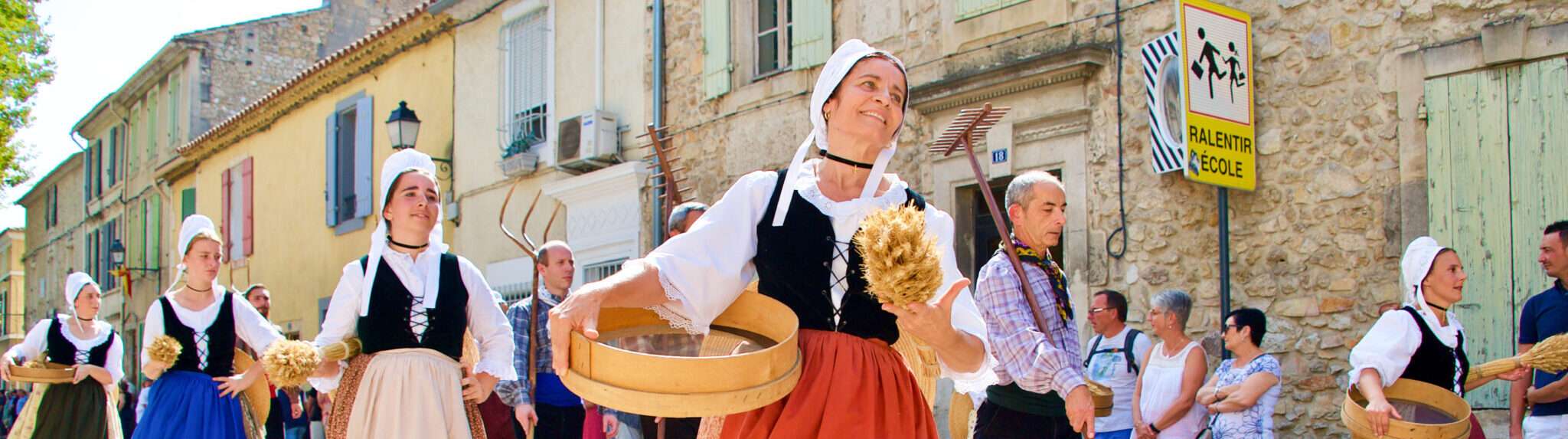 フランスの通りを歩く伝統的な衣装を着た人々のグループ。