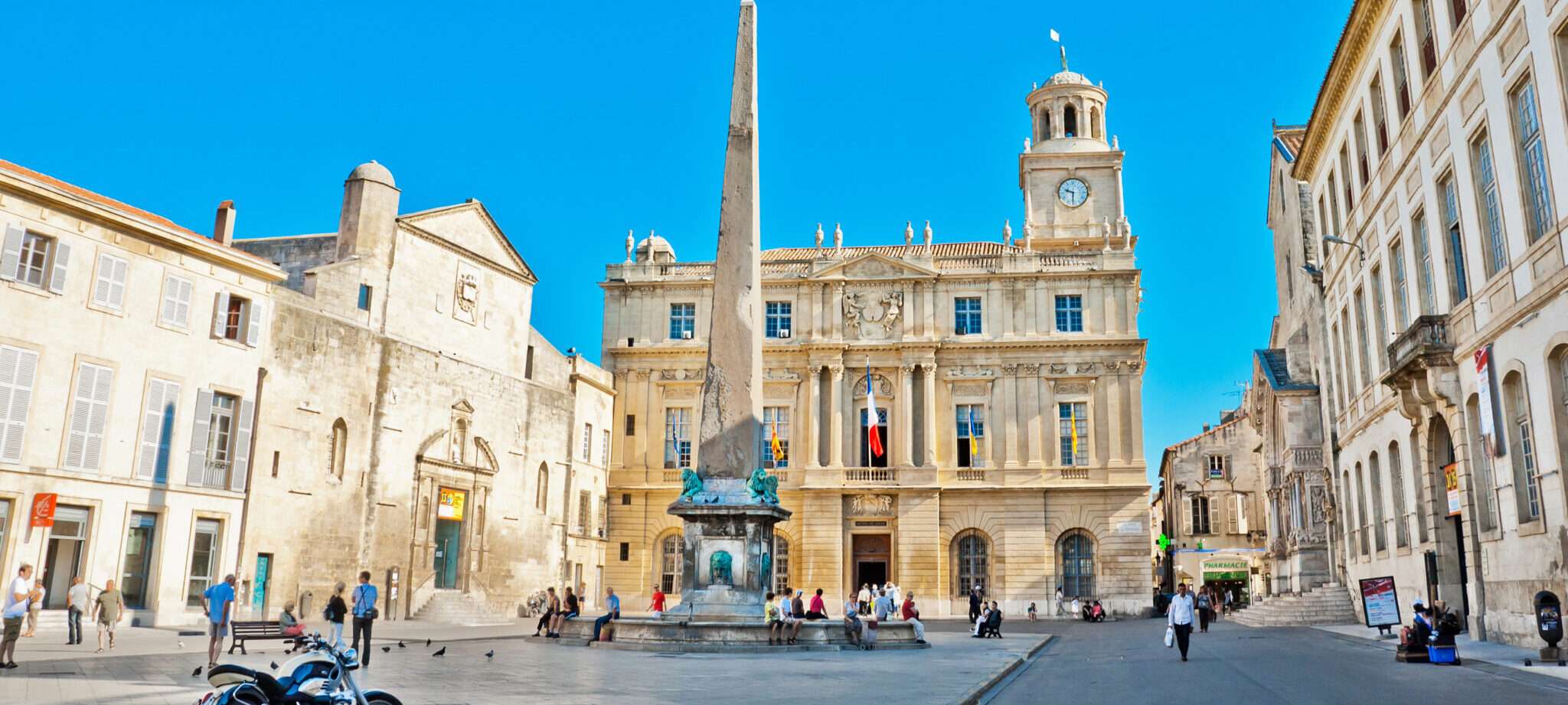 時計塔とその前にバイクが停まっているフランスの広場。