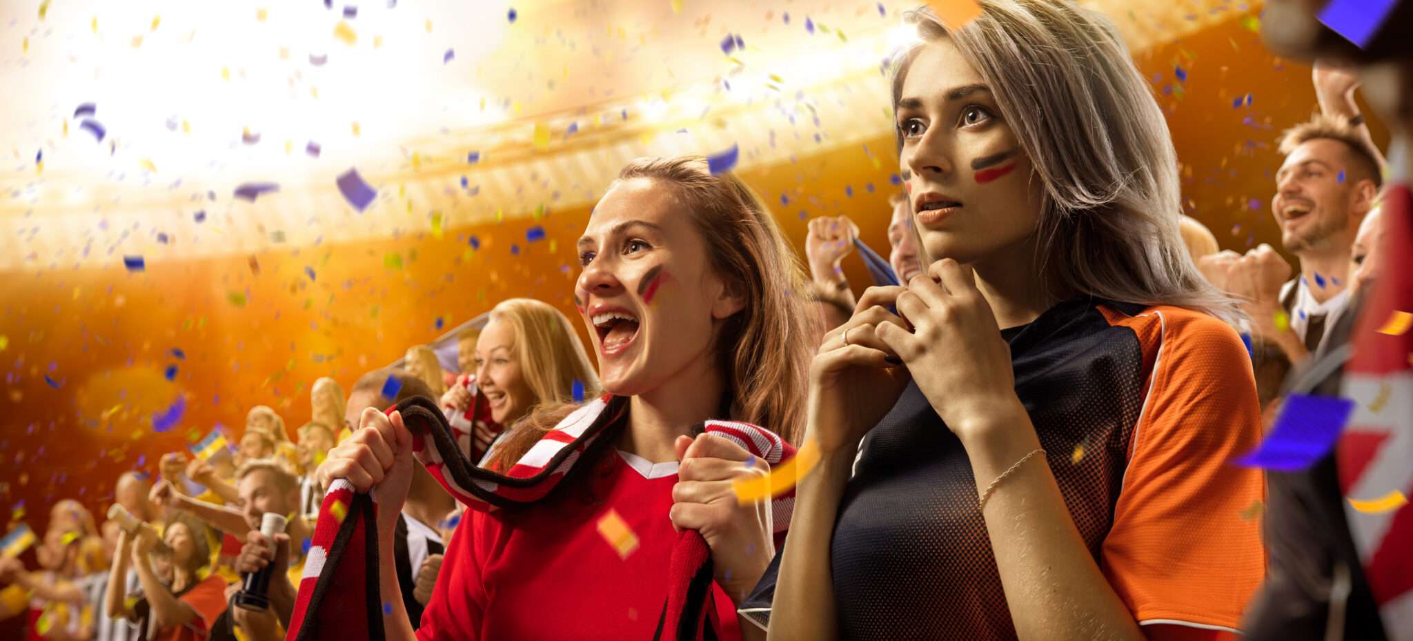 紙吹雪が舞うスタジアムでフランスの勝利を祝う人々のグループ。