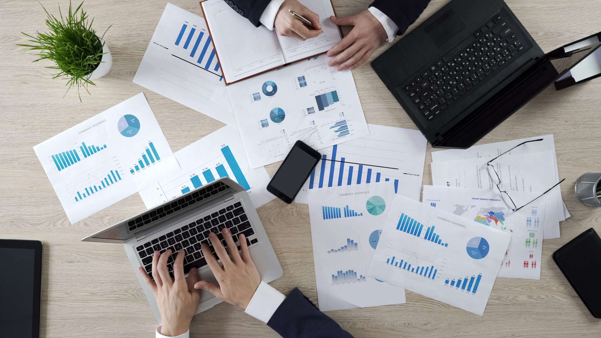 ラップトップとグラフを操作するフランスのビジネスマンのグループ。