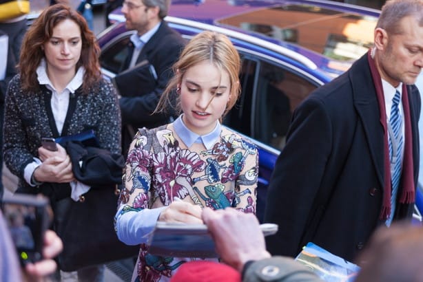 フランスで大勢の人々の前でタブレットにサインする女性。