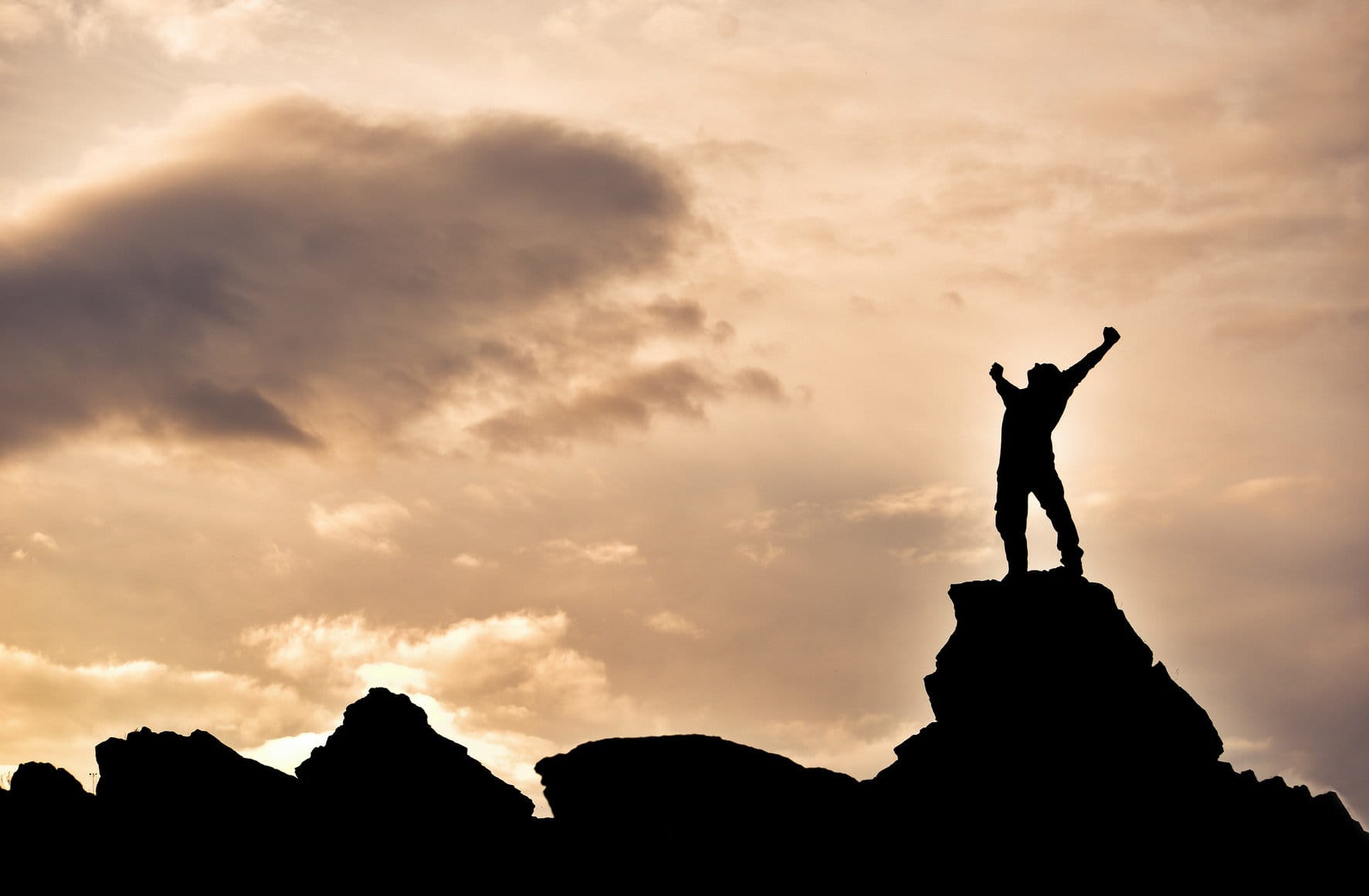 フランスの山の頂上に立つ男性のシルエット。