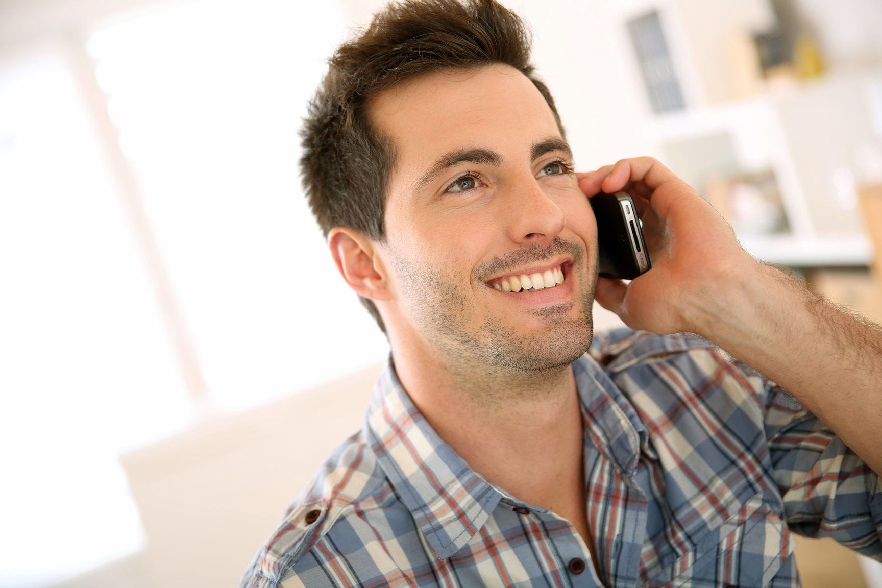 フランスで携帯電話で話しながら微笑む男性。