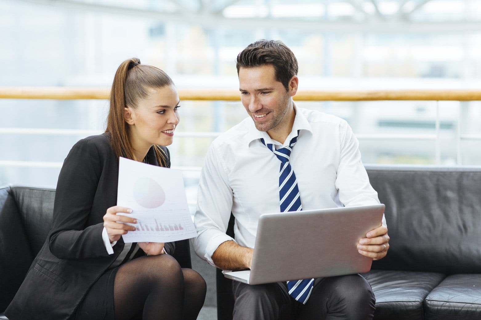 フランスでソファに座ってラップトップを見ている男性と女性。