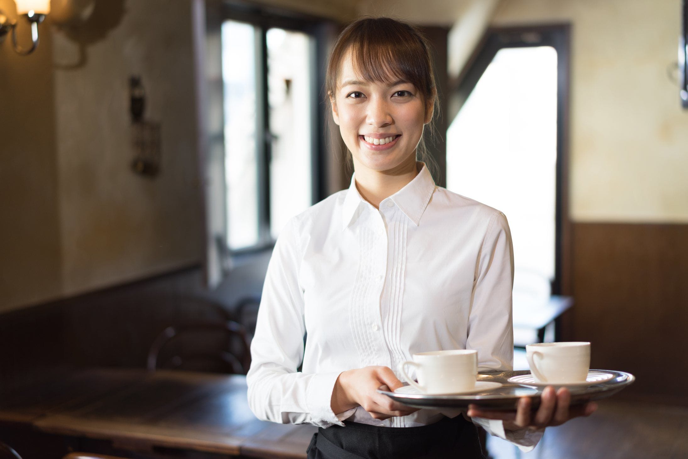 一杯のコーヒーを持っているフランス人のウェイトレス。