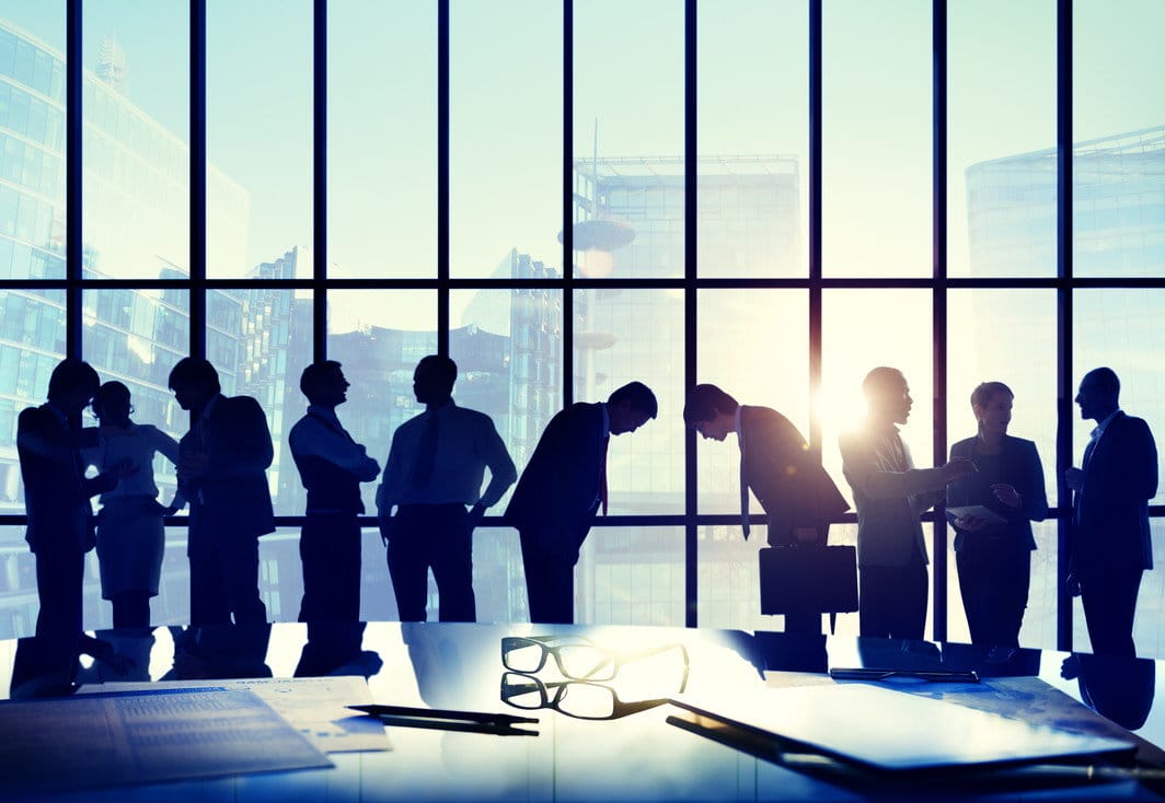 フランスの窓の前に立つビジネスマンのシルエット。