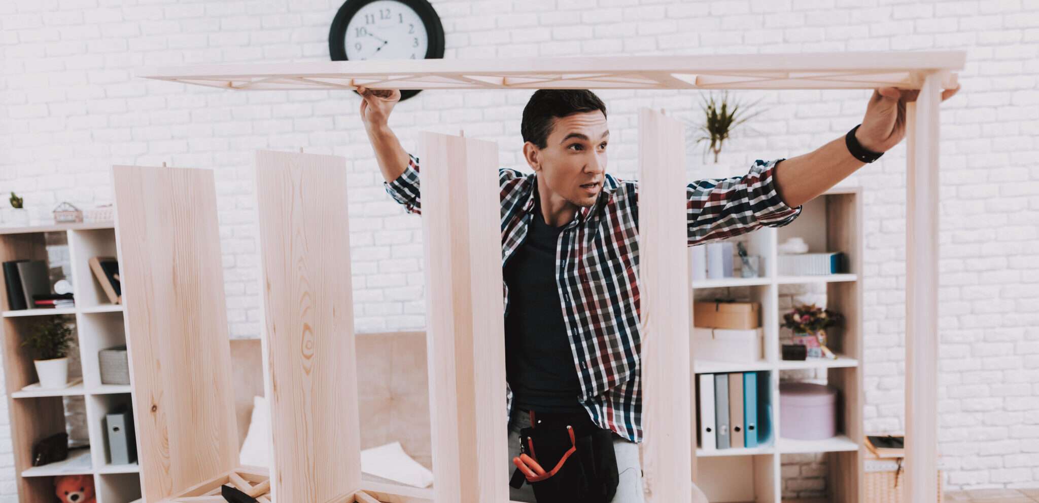 フランスの部屋で男性が木枠を掲げている。