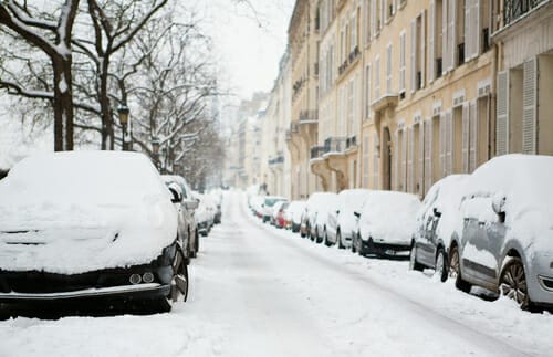 フランス、パリの雪の多い路上に駐車された車。 フランス、パリの雪の多い路上に駐車された車。