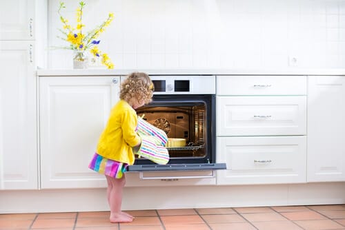 フランスの白いオーブンの前に立つ少女。