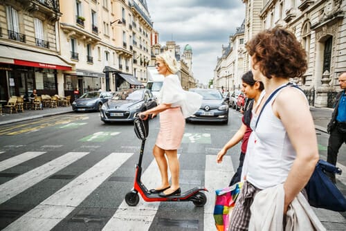フランスの路上で電動スクーターに乗る女性。