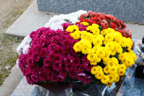 墓の上に繊細に置かれた、花瓶に盛られた美しい花。