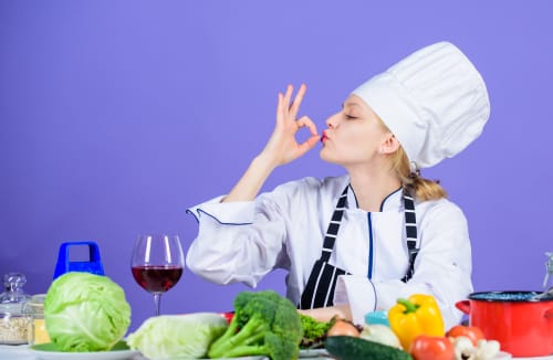 フランス料理をイメージしたシェフハットをかぶった女性が身振り手振りをしている。