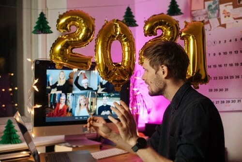 フランスで机の上に風船を置き、コンピューターの前に立つ男性。 フランスで机の上に風船を置き、コンピューターの前に立つ男性。