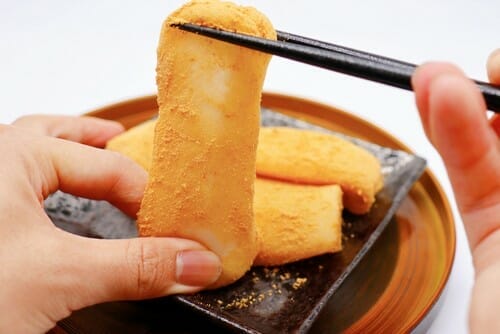 フランスで人が箸でパンを持っています。