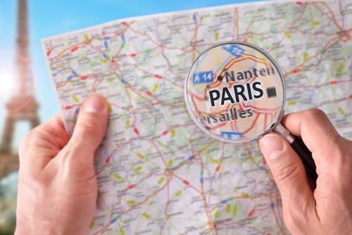 フランスの地図の上に虫眼鏡を持っている人。