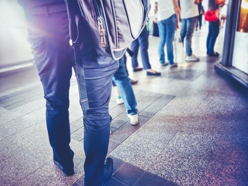 フランスでバックパックを背負って列に並ぶ人々。