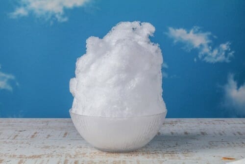 フランスの青い背景の上に置かれた白い泡のボウル。 フランスの青い背景の上に置かれた白い泡のボウル。