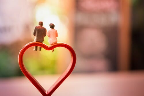 フランスのハート型の置物の上に座るカップル。 フランスのハート型の置物の上に座るカップル。