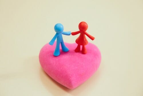 フランスのピンクのハートの上で手を繋ぐ 2 人。