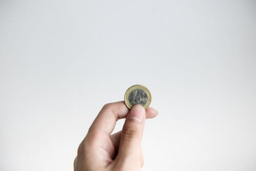 白い背景にフランスのコインを持つ人の手。 白い背景にフランスのコインを持つ人の手。