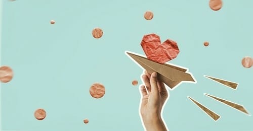 フランスをイメージした、ハートのついた紙飛行機を持つ手。 フランスをイメージした、ハートのついた紙飛行機を持つ手。