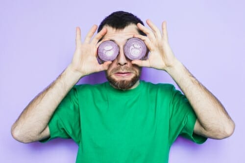 フランスから来た男性が玉ねぎで目を覆っています。 フランスから来た男性が玉ねぎで目を覆っています。