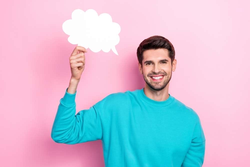 フランスのピンクの背景に吹き出しを持つ男性。 フランスのピンクの背景に吹き出しを持つ男性。