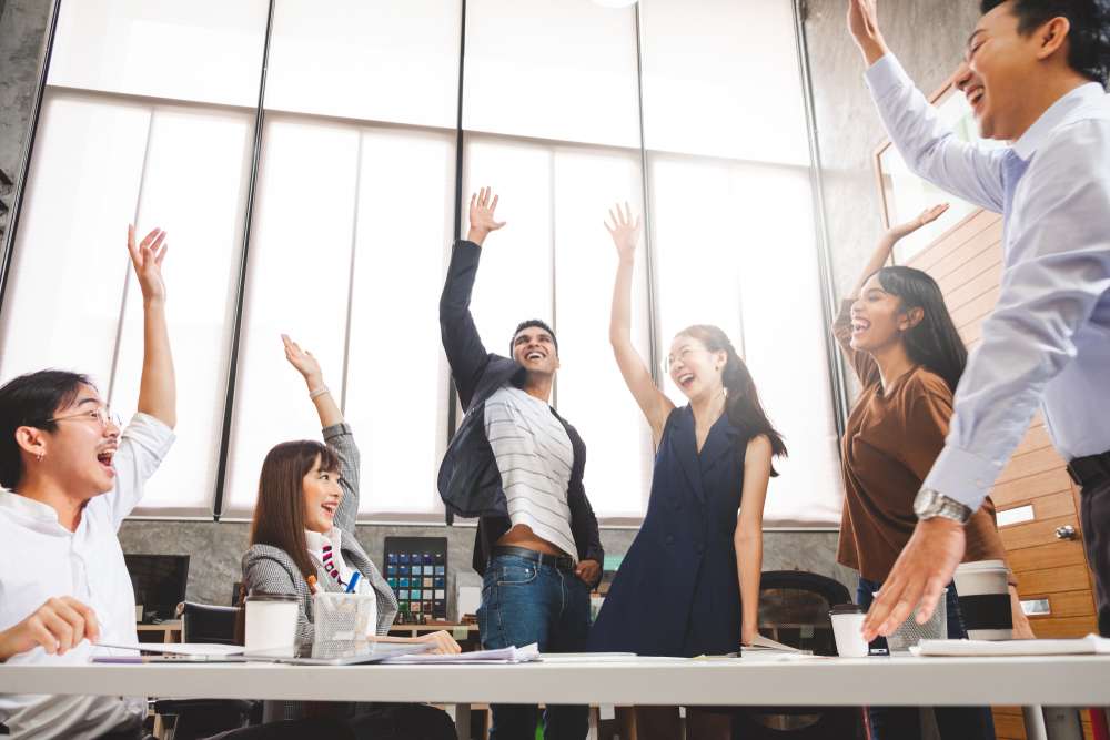 フランス オフィスで手を上げる人々のグループ。