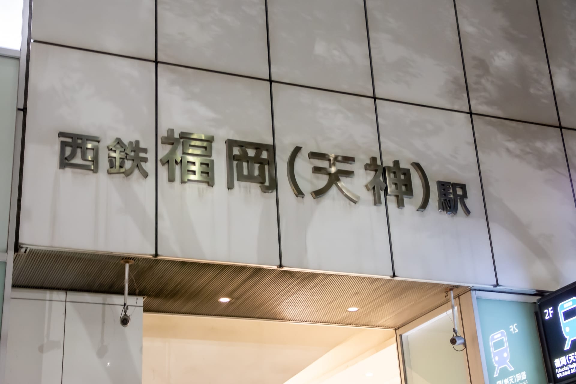 西鉄福岡（天神）駅の外観は、さわやかな白壁に日本語の看板が特徴的で、天神（福岡）の魅力を表しています。.